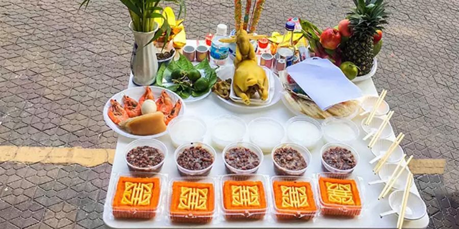 Mâm cúng xe mới đơn giản nhưng đầy đủ nghi lễ: hoa, gà luộc, trái cây, bánh ngọt và hương nhang